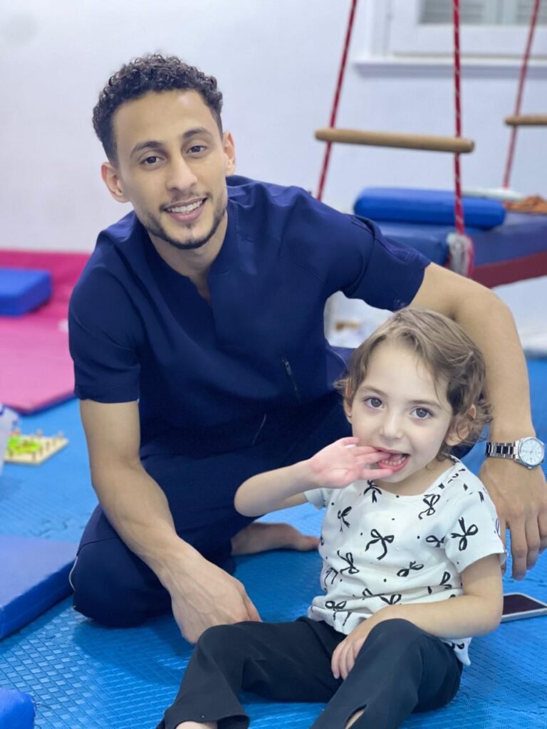 أخصائي مع طفلة في مساحة التدريب بالمركز