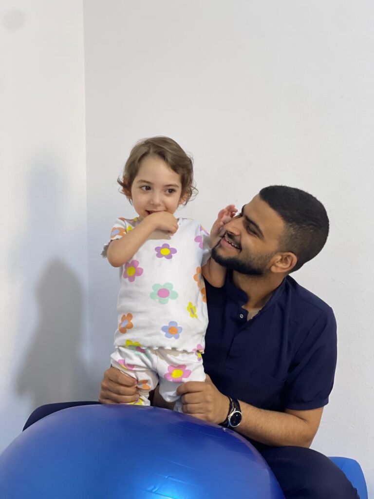 أخصائي يتفاعل مع طفلة أثناء جلسة داخل المركز