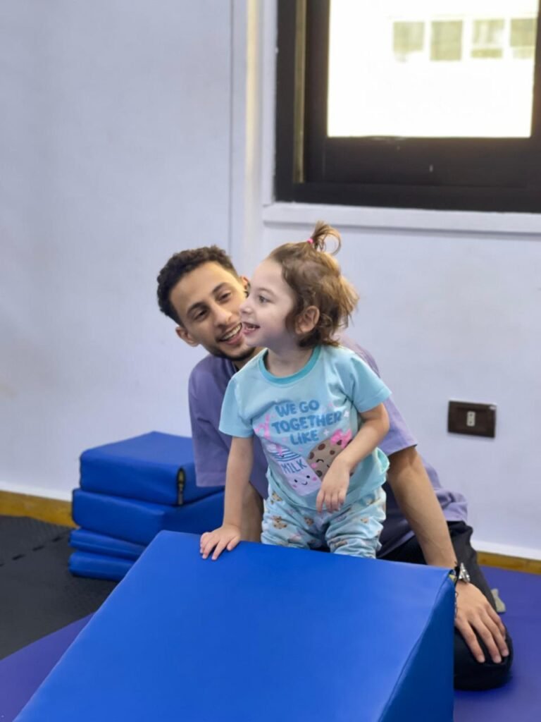 أخصائي مع طفلة داخل غرفة التأهيل