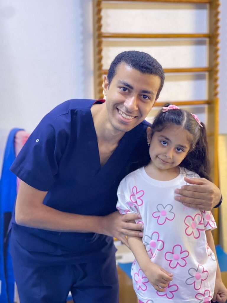 أخصائي وطفلة يبتسمان داخل مركز بداية جديدة